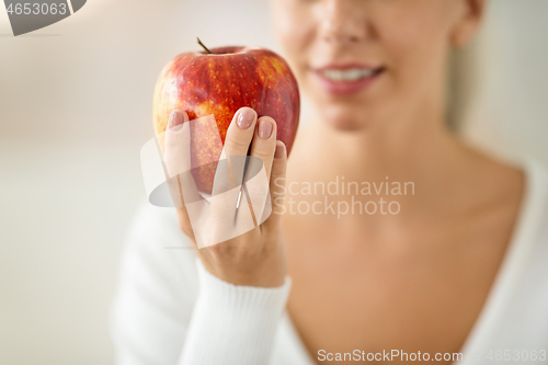 Image of close up of woman holding ripe red apple