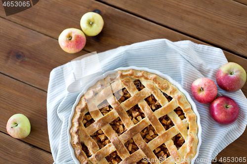 Image of apple pie in baking mold on wooden table