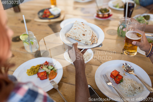 Image of international friends eating at restaurant