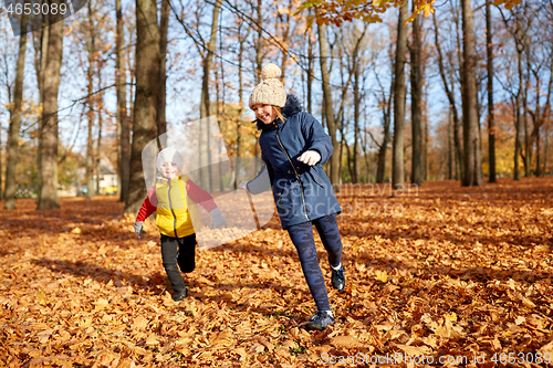 Image of happy children running at autumn park