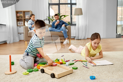 Image of brother and sister playing and drawing at home