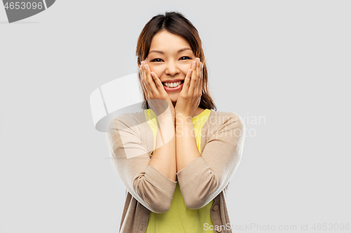 Image of happy amazed asian woman over grey background