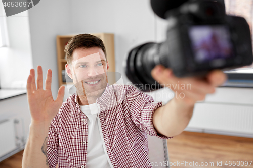 Image of male video blogger with camera blogging at home