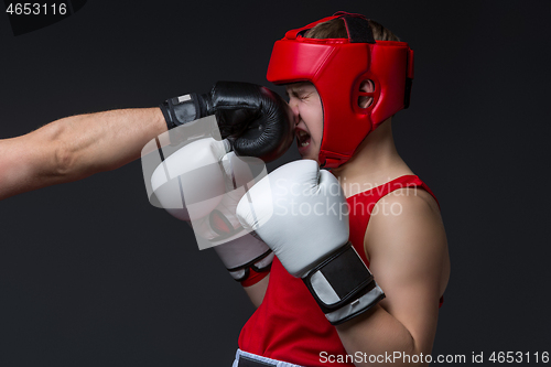 Image of young boxer is being punched