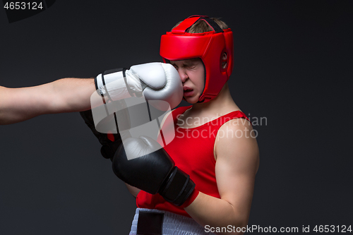 Image of young boxer is being punched