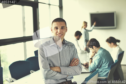 Image of business man  on a meeting in offce with colleagues in backgroun