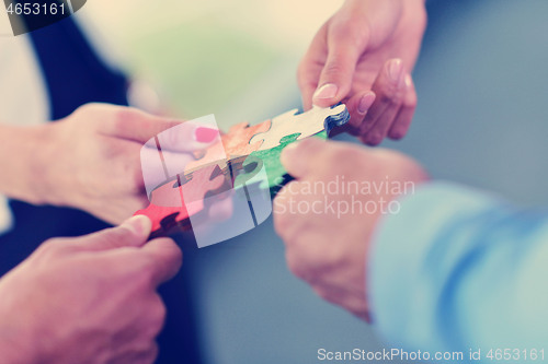 Image of Group of business people assembling jigsaw puzzle