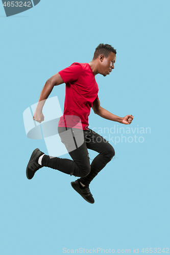 Image of Freedom in moving and forward motion. The happy surprised young afro man jumping