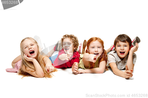 Image of Close-up of happy children lying on floor in studio and looking up, isolated on white background