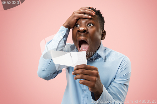 Image of Young boy with a surprised expression bet slip on pink background