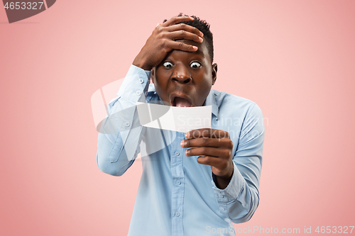 Image of Young boy with a surprised expression bet slip on pink background