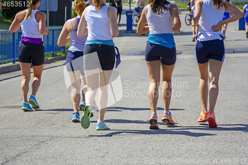 Image of Group Young girls friends running on the city street