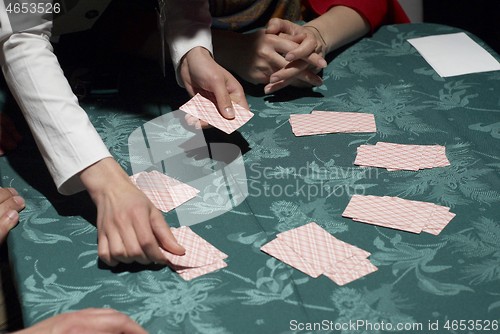 Image of Female croupier shuffling cards on gambling table