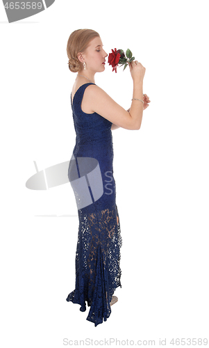 Image of Woman standing in dress with rose