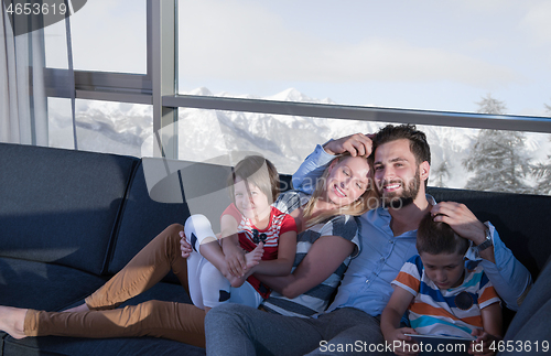 Image of happy young couple spending time with kids at home