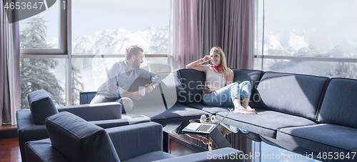 Image of couple relaxing at  home using tablet computer