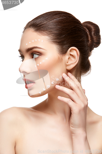 Image of girl applying foundation on face isolated on white