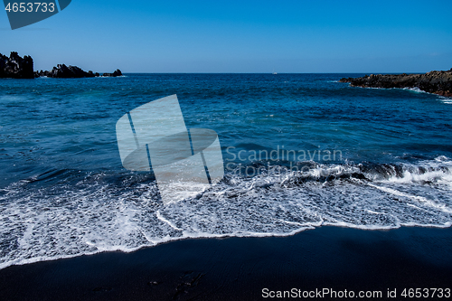 Image of beautiful view on ocean water and black lava sand