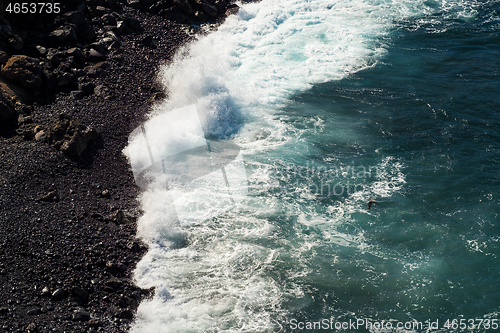 Image of beautiful view on ocean water and black lava sand