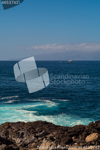 Image of beautiful view on ocean water and black lava sand