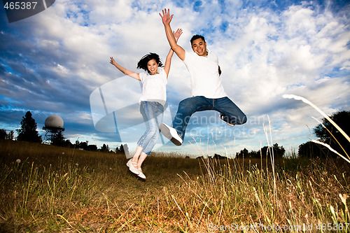 Image of Asian couple jumping for joy