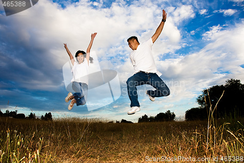 Image of Asian couple jumping for joy