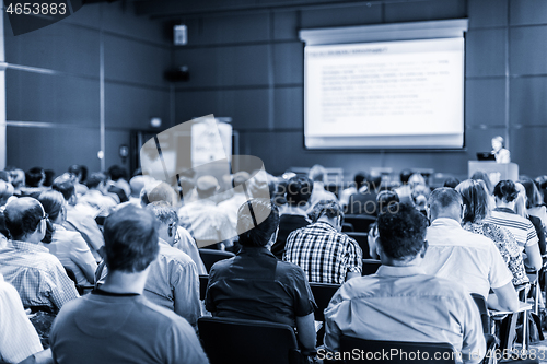 Image of Woman giving presentation in lecture hall at university.