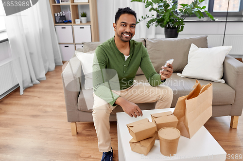 Image of indian man checking takeaway food order at home