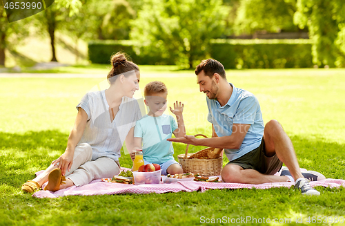 Image of happy family having picnic at summer park