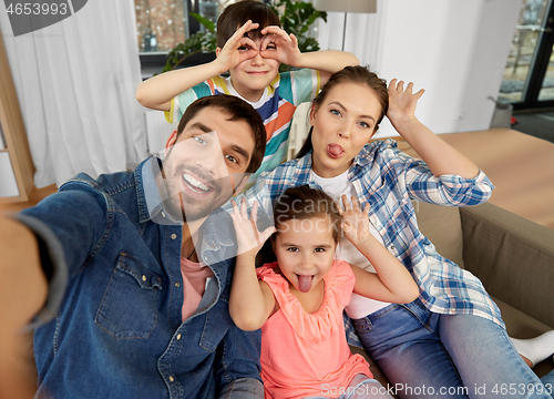 Image of family taking selfie and making faces at home
