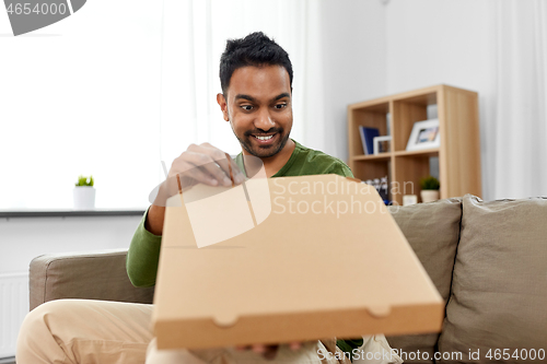 Image of indian man looking inside of takeaway pizza box