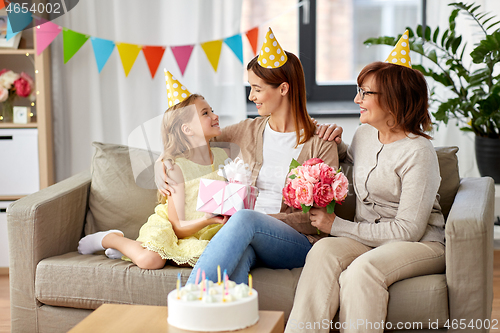 Image of daughter with gift box greeting mother on birthday