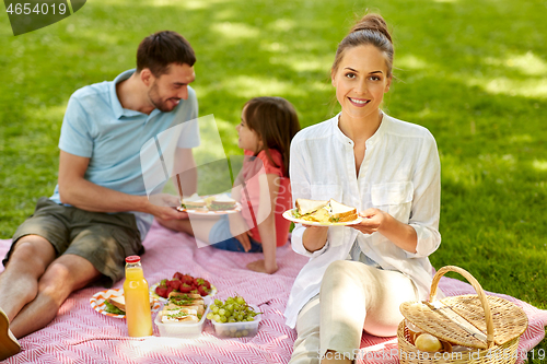 Image of happy family having picnic at summer park