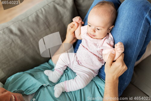 Image of middle aged father with baby lying on sofa at home