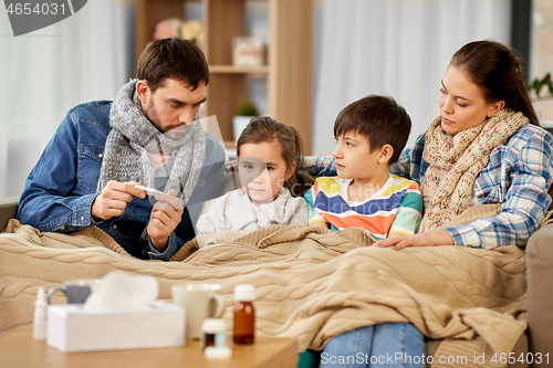 Image of family with ill children having fever at home