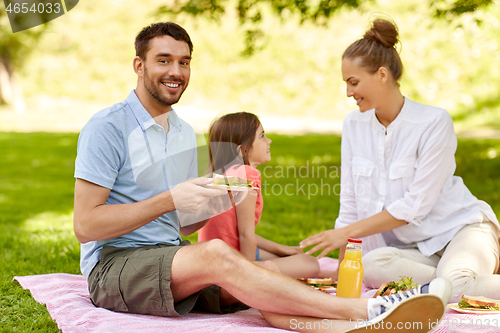 Image of happy family having picnic at summer park