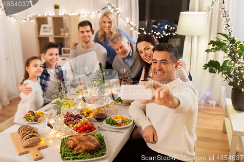 Image of family having dinner party and taking selfie