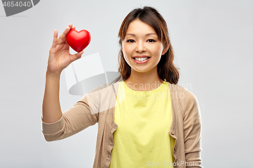 Image of happy asian woman holding red heart