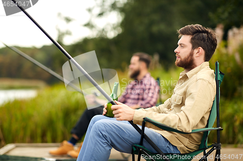 Image of friends fishing and drinking beer at lake