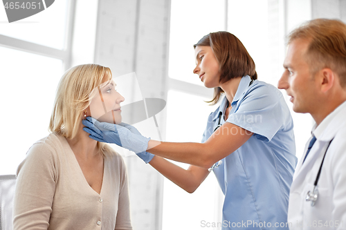 Image of doctor checking patient\'s tonsils at hospital