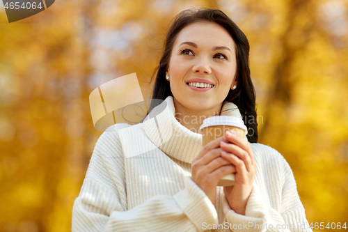 Image of woman drinking takeaway coffee in autumn park