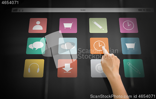 Image of hand using interactive panel with app icons on it