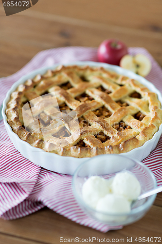 Image of apple pie with ice cream on wooden table