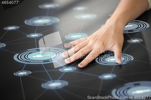 Image of hand using interactive panel with network icons