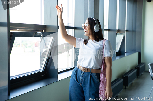 Image of Young woman waiting for departure in airport, traveler with small baggage, influencer\'s lifestyle