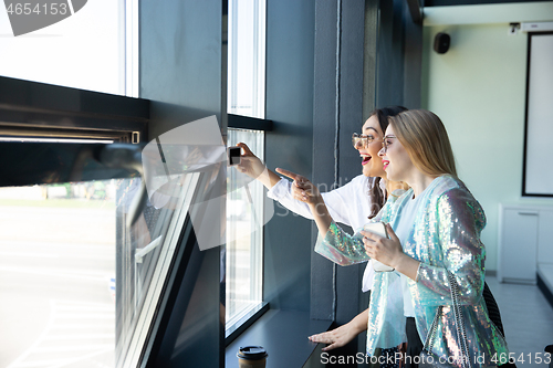 Image of Young women waiting for departure in airport, traveler with small baggage, influencer\'s lifestyle