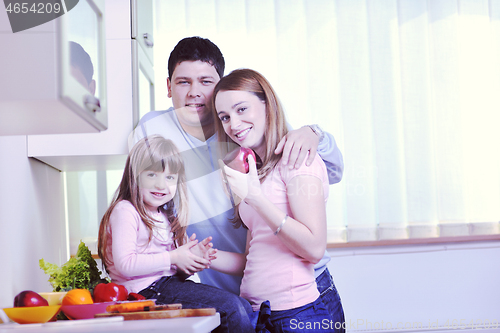 Image of happy young family in kitchen