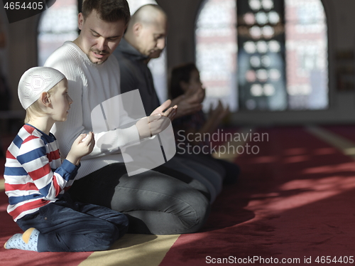 Image of father and son in mosque praying