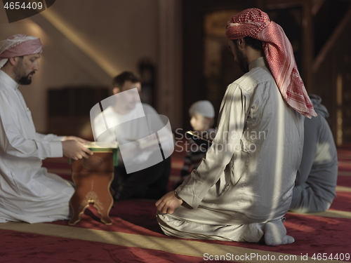 Image of muslim people in mosque reading quran together