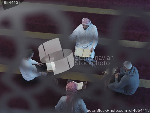 Image of top view of muslim people in mosque reading quran together